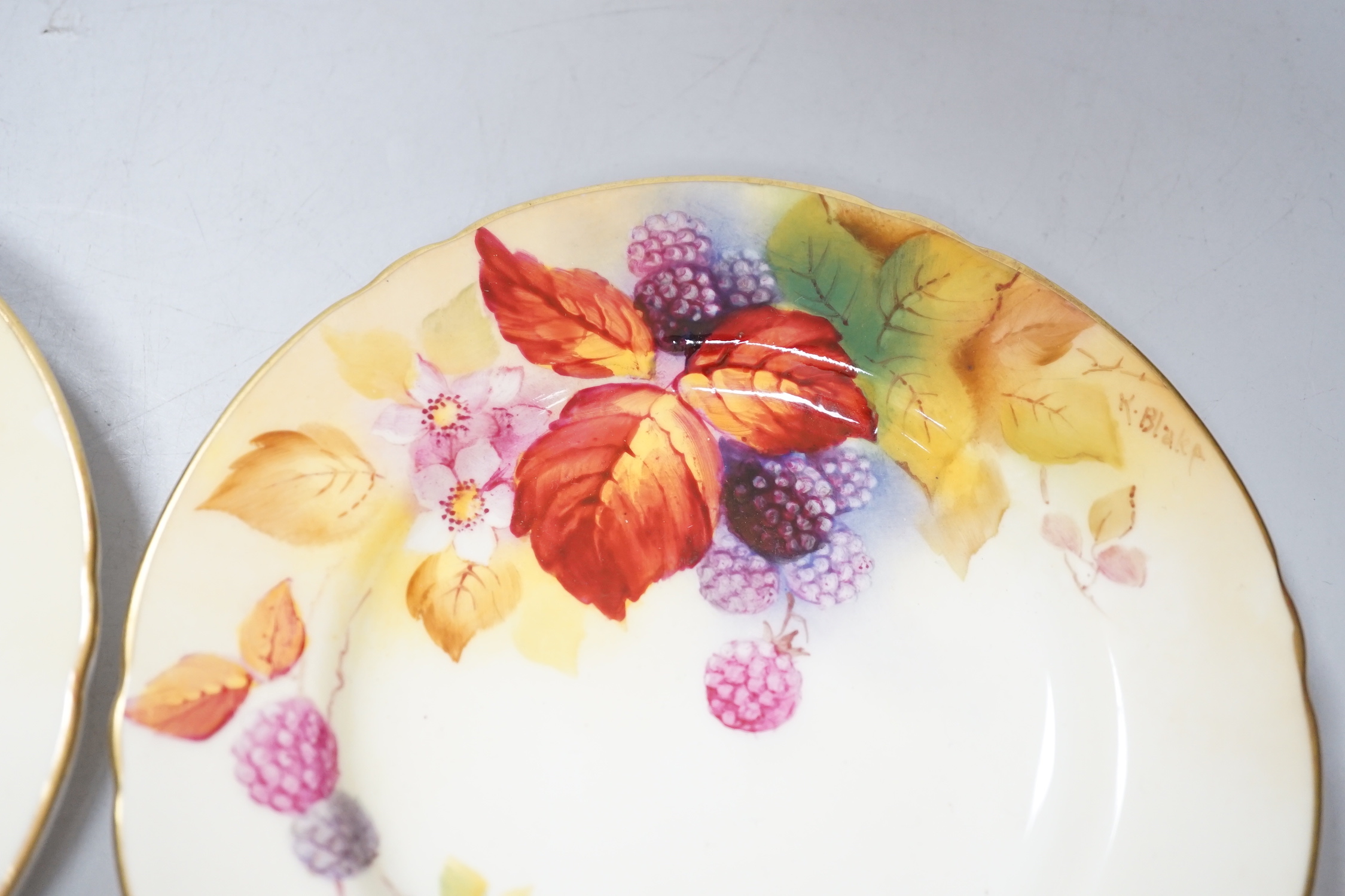 A pair of Royal Worcester lobed tea plates painted with autumnal leaves and berries by Kitty Blake, signed date mark 1935